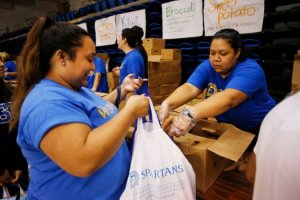 Alisa Patterson, 32, at right, distributes sweet potaoes as San Jose State University student Giovanna Diaz, 21, at left, receives food from Second Harvest Food Bank's Just-in-Time Mobile Food Pantry at San Jose State University Monday, Nov. 14, 2016, in San Jose, Calif. The food bank distributed 27,500 pounds of food served 545 students. Recent surveys indicate roughly half of SJSU students are skipping meals because of costs and at least 20 percent of California State University students are food insecure. (Jim Gensheimer/Bay Area News Group)